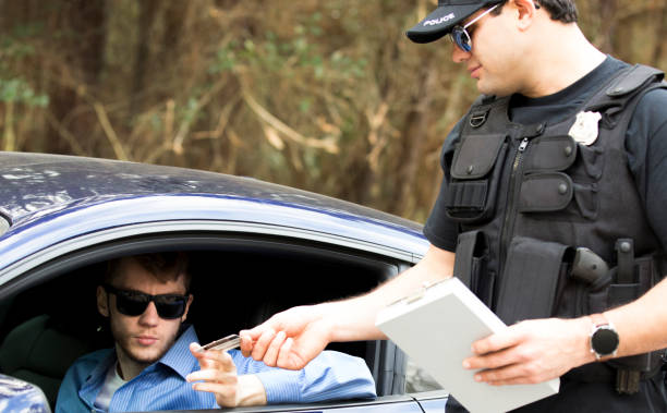 friendly police officer stops a young man on a rural road. - speeding ticket imagens e fotografias de stock