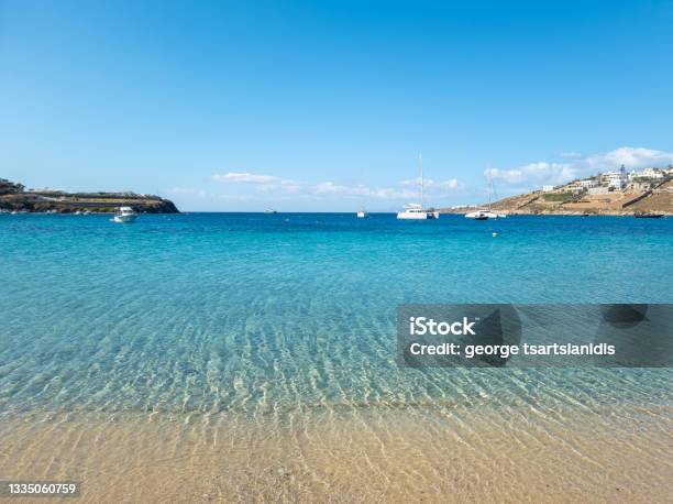 Ornos Empty Sandy Beach Calm Sea Moored Yachts Background Mykonos Island Cyclades Greece Stock Photo - Download Image Now