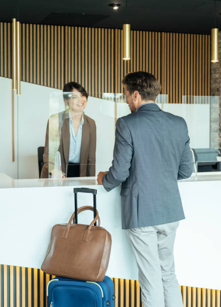 istock Female Hotel Receptionist Assisting Businessman for Checking In 1335061110