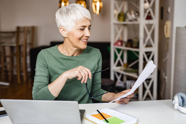 istock Woman looking at papers while working at home 1335062374