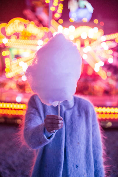 Cotton candy at the festival Young woman holding cotton candy. candyfloss stock pictures, royalty-free photos & images