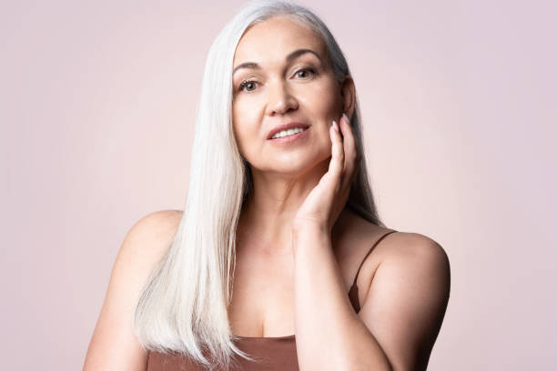 headshot middle aged gray-haired female touching healthy groomed perfect face skin. natural beauty and aging concept - make up women ceremonial makeup senior women imagens e fotografias de stock