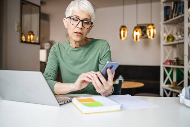 istock Modern mature woman using smart phone 1335063470