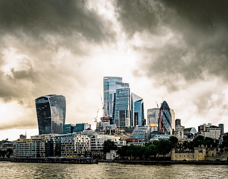 Stormy evening clouds over the financial towers of the City of London, as seen from across the river Thames.