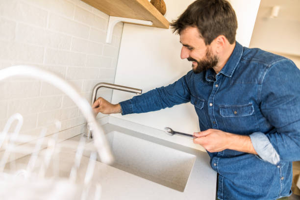 istock Young man fixing a water tap in the kitchen. 1335066843