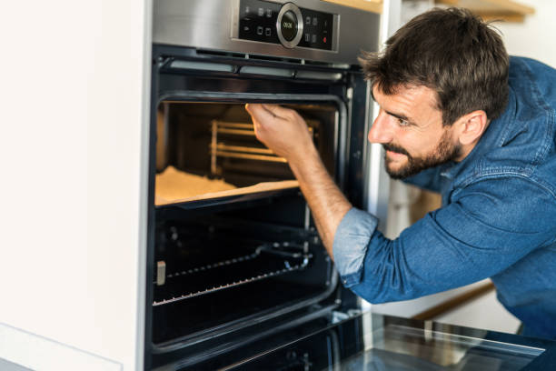 istock Young man fixing an oven at home. 1335066866