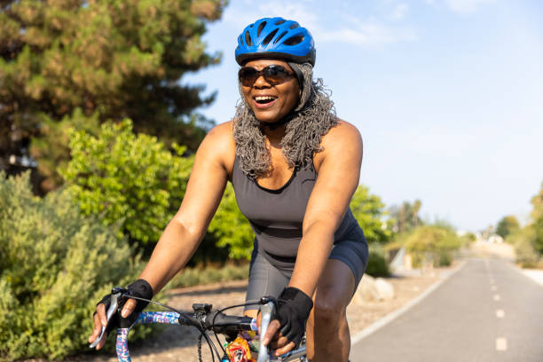 senior black woman in bicicletta - cyclist cycling road women foto e immagini stock