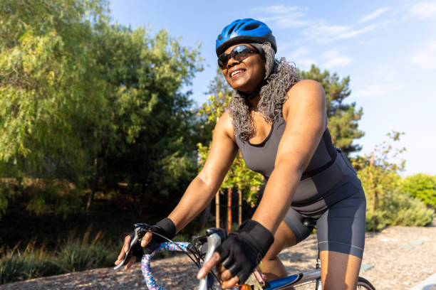 senior black woman in bicicletta - cyclist cycling road women foto e immagini stock