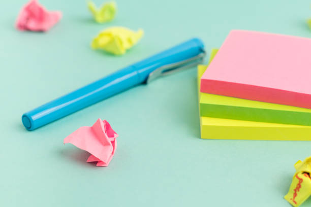 istock Crumpled papers, pen and empty colorful sticky note paper on turquoise background. Selective Focus. 1335070505
