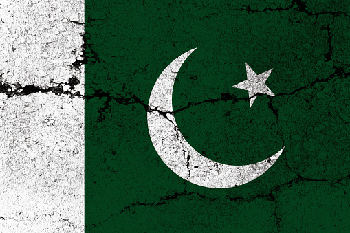 Pakistani Flag on cracked wall background.