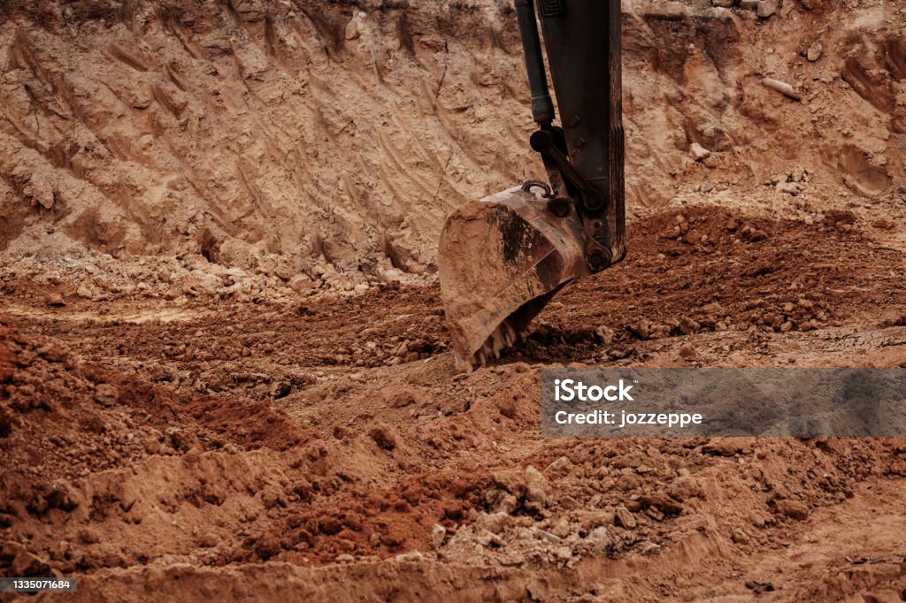 Backhoe working construction site. Backhoe working by digging soil at construction site. Crawler excavator digging on dirt. Excavation vehicle. Earthwork Stock Photo