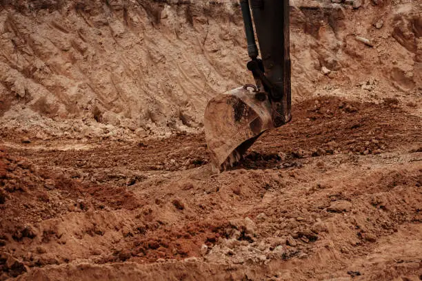 Backhoe working by digging soil at construction site. Crawler excavator digging on dirt. Excavation vehicle.