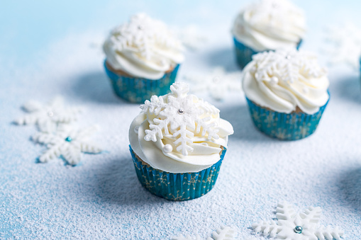 Christmas theme, snowflakes cupcakes on a blue background and snow.