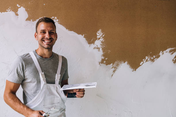 portrait of a happy young man plastering wall in his workshop - plaster plasterer wall repairing imagens e fotografias de stock