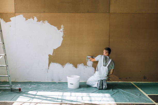 istock Back View of An Anonymous Man Plastering Wall with Spatula 1335074931