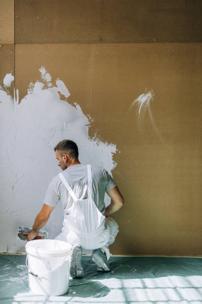 istock Back View of a Man Plastering Wall with Spatula at Home 1335074938