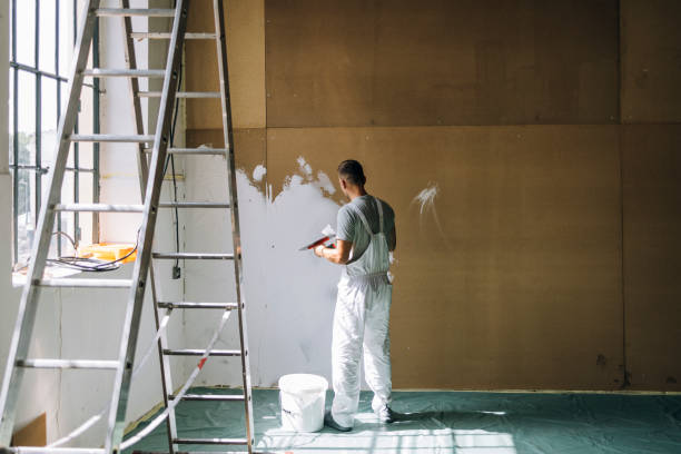 istock Back View of An Anonymous Man Plastering Wall with Spatula 1335074969