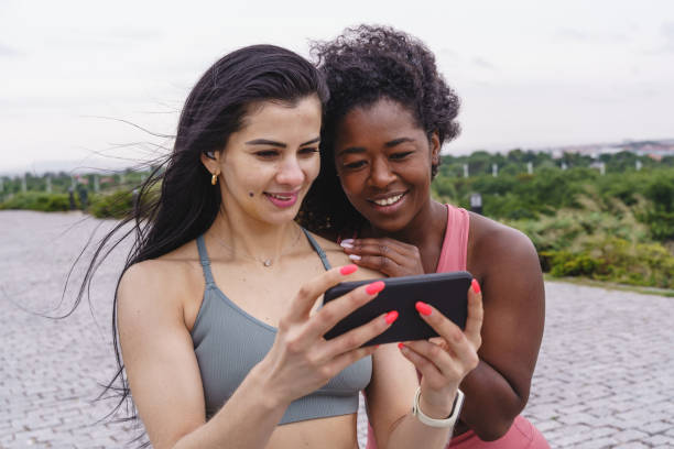 istock Girlfriends in sportswear using smartphone. 1335077166