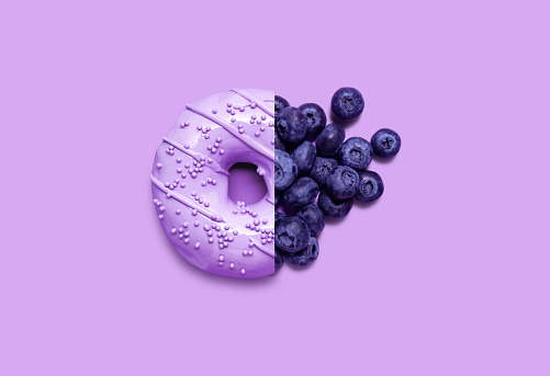 Creative food diet concept photo of donut with blueberry fruit.