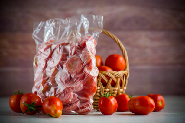 frozen tomatoes in a vacuum bag on table stock photo