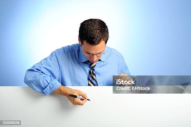 Businesman Leaning On White Card Holding Pen With Blue Background Stock Photo - Download Image Now