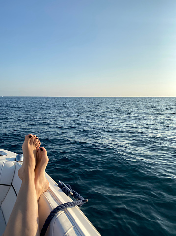 Woman relaxing her feet over the edge of boat. Travel concept.