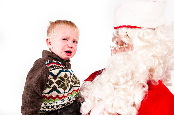 distraught little boy with santa stock photo