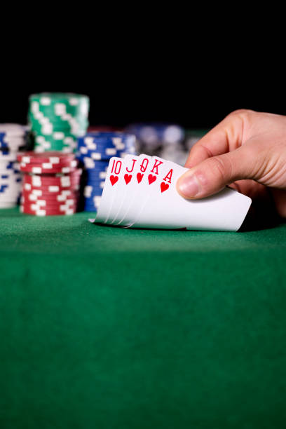 Hand with royal Flush in poker and betting chips stock photo