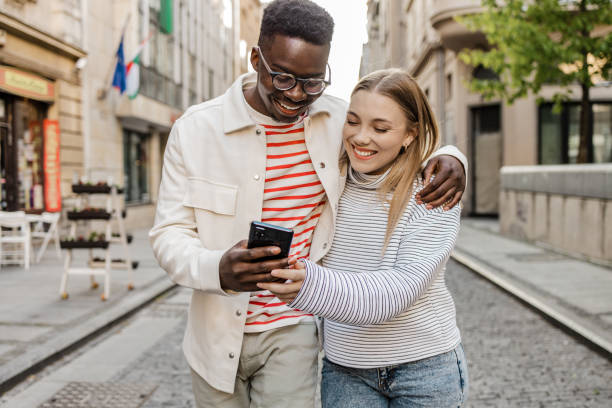 istock Friends walking and using mobile phone on the move 1335083585