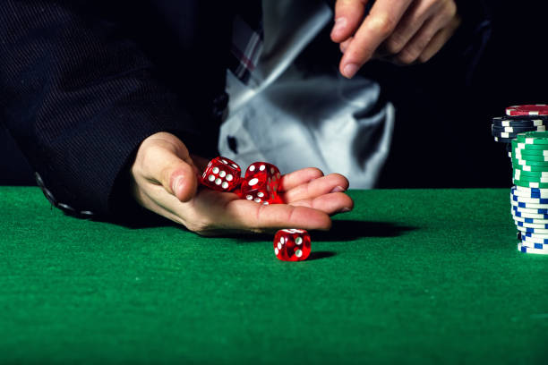 istock Close-up of hands throwing dice in casino 1335083664