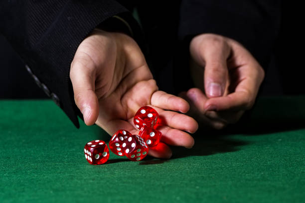 istock Close-up of hands throwing dice in casino 1335083669