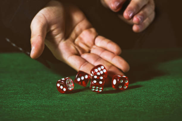 istock Close-up of hands throwing dice in casino 1335083671