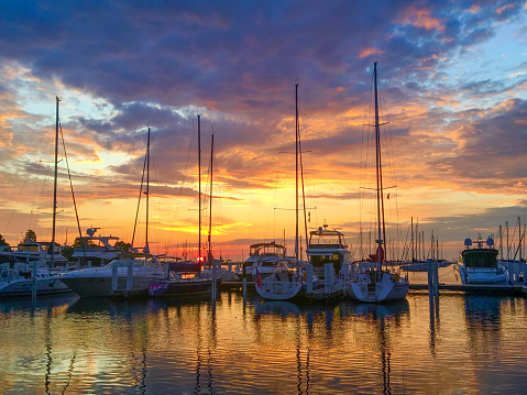 Sun rising over sailboats in the harbor