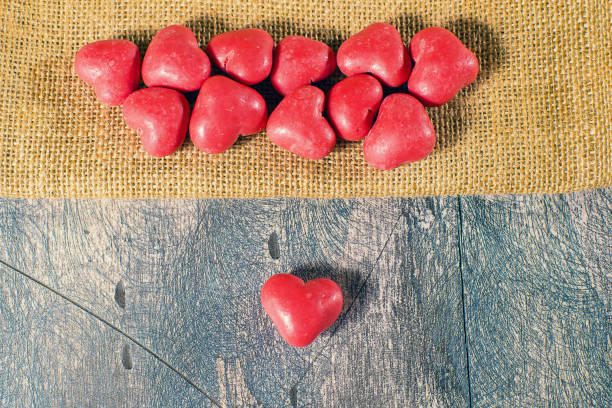 heart shaped candies on wooden table and sack - valentines day candy chocolate candy heart shape imagens e fotografias de stock