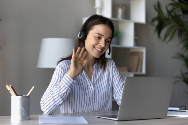 istock Smiling young woman wave talking on video call on laptop 1335085211