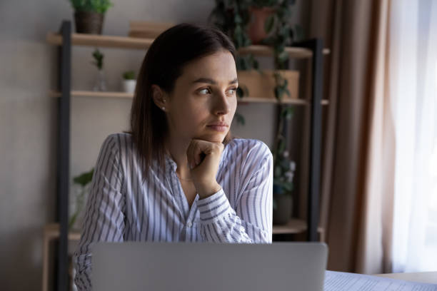 istock Serious young woman distracted from computer job thinking 1335085222