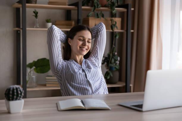 istock Happy young woman relax at table at workplace 1335085241