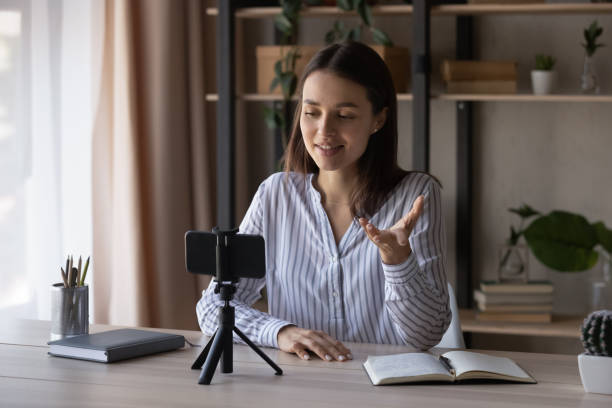 istock Smiling woman record video on smartphone device 1335085249