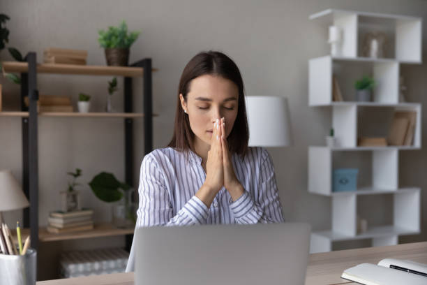 istock Superstitious young woman worker pray at workplace 1335085256