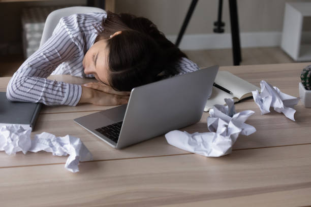 istock Exhausted woman fall asleep on desk at workplace 1335085271