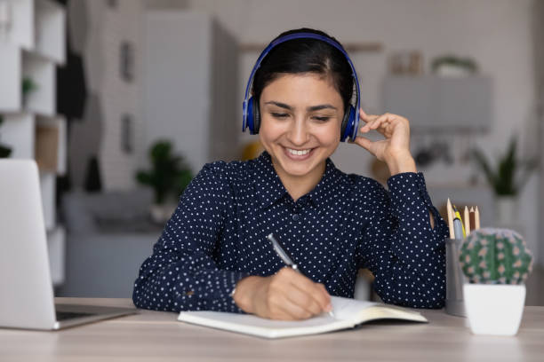 istock Smiling Indian female in headset study online on computer 1335085286