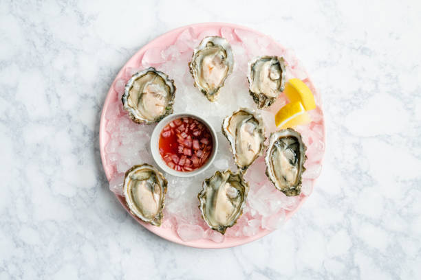 overhead view of fresh oysters on a plate with mignonette - pacific oyster imagens e fotografias de stock