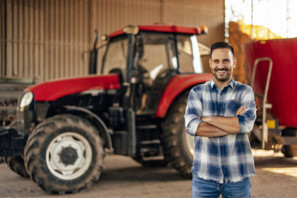 istock Adult man, showing off his tractor. 1335086387