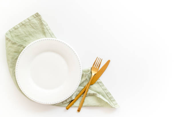 istock Empty tableware with tablecloth top view. Plate with fork and knife on napkin 1335088783