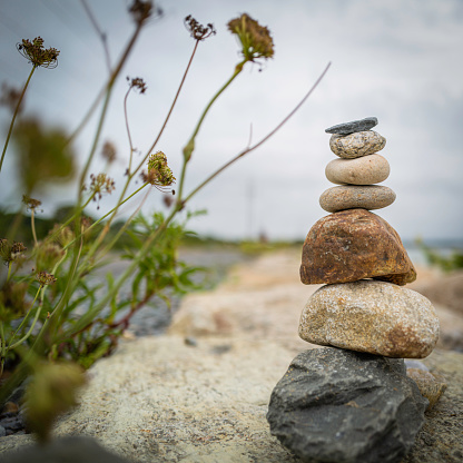 Stones stacked on the beach on Cape Cod. Image for mindfulness, inner strength, stability, and balance with space for text and design.