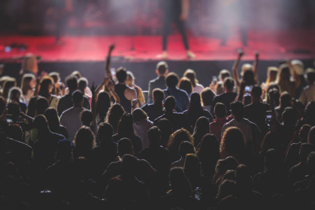 istock A crowded concert hall with scene stage lights, live show performance, with people silhouette, dance floor air during a concert open-air festival 1335094086