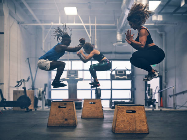 atletas de treinamento cruzado em uma academia - exercising women men group of people - fotografias e filmes do acervo