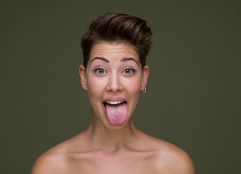 Young woman sticking out tounge, close up portrait