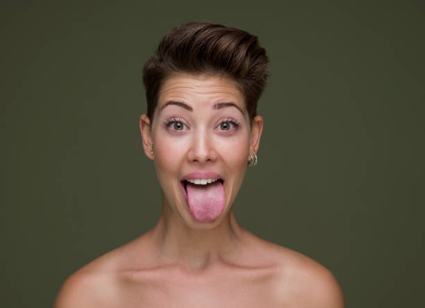Young woman sticking out tounge, close up portrait Young woman sticking out tounge, close up portrait protruding stock pictures, royalty-free photos & images