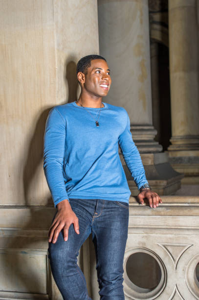 Portrait of Young Black College Student standing inside office building, looking forward